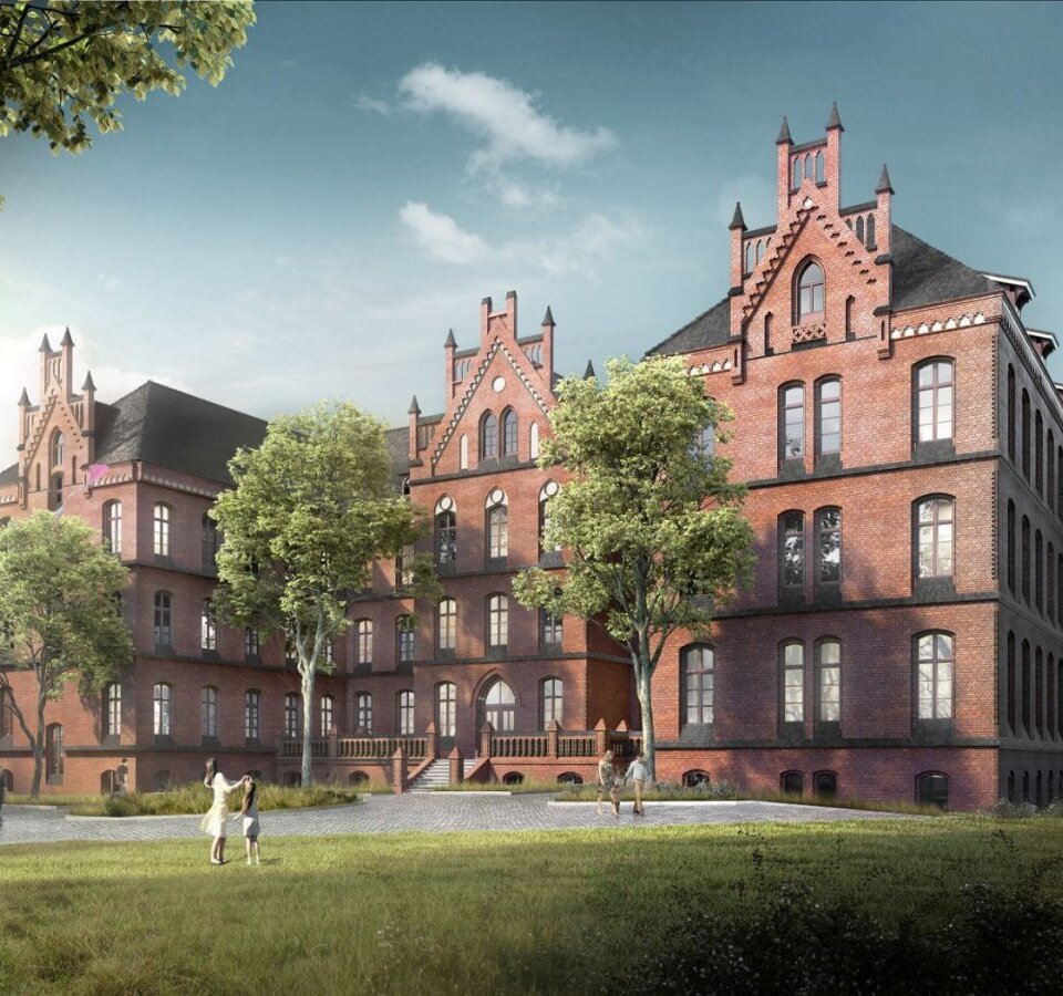 Historyczny czerwony budynek hotelu z neogotycką architekturą otoczony zielenią i drzewa, goście spacerują przy wejściu