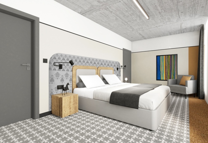 Modern double hotel room with queen bed, patterned carpet, wooden bedside table, reading lamps, armchair and colorful wall art