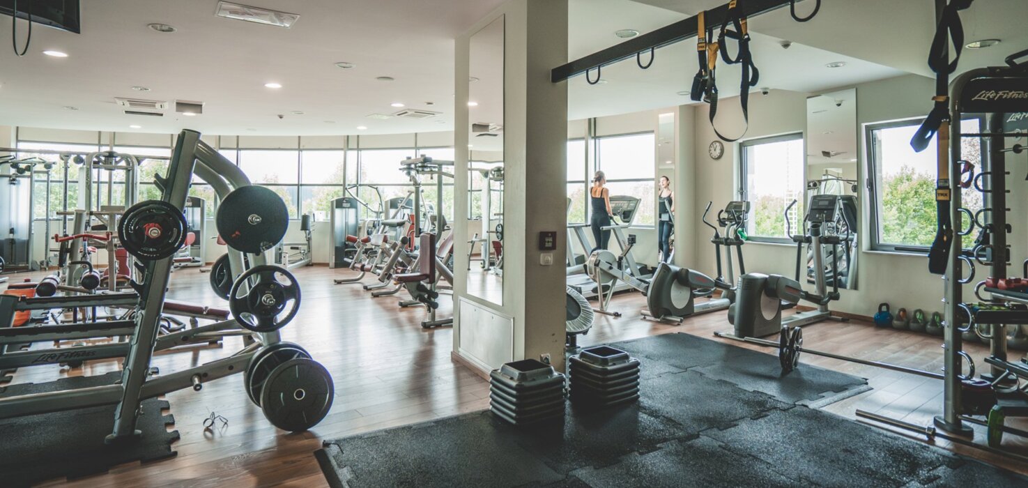 Nowoczesna siłownia hotelowa z widokiem na ogród