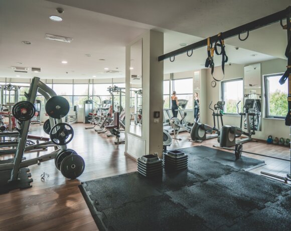 Nowoczesna siłownia hotelowa z widokiem na ogród