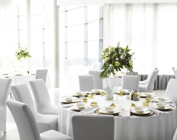 Dekoracyjny stół pary młodej na tle świec i kwiatów