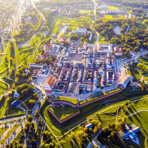 Widok z lotu ptaka na ufortyfikowane zabytkowe miasto z rynkiem, bastionami w kształcie gwiazdy i słonecznymi parkami.