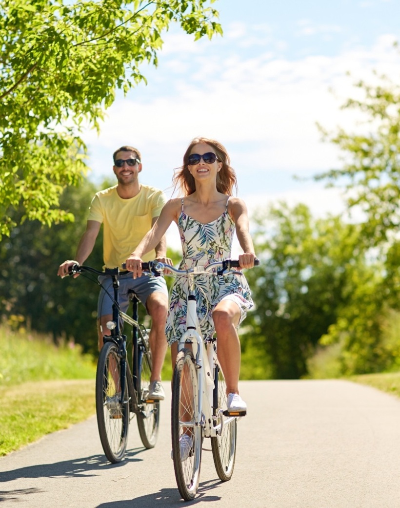 Eine Frau und ein Mann fahren Fahrrad auf deinem Weg in der grünen Natur
