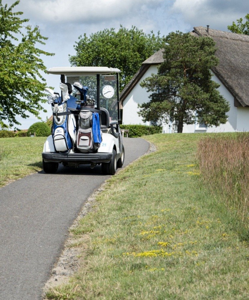 Ein Golfcart mit Fahrtrichtung zum Golfhus des Resort Balmer See auf Usedom