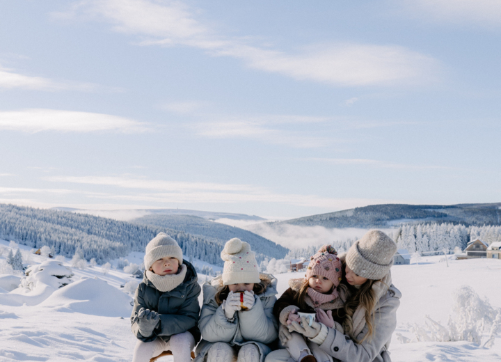 Family with children enjoying snowy mountain landscape during a winter holiday at a mountain resort