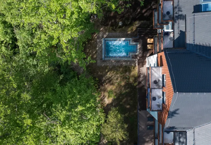 Nowoczesny hotel otoczony zielonym lasem z prywatnym jacuzzi na zewnątrz i balkonami pokoi z widokiem na naturę