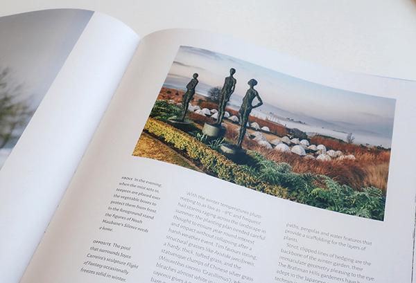 Brochure page showing seaside sculpture garden — three standing bronze figures among grasses, domes and a misty coastal view.