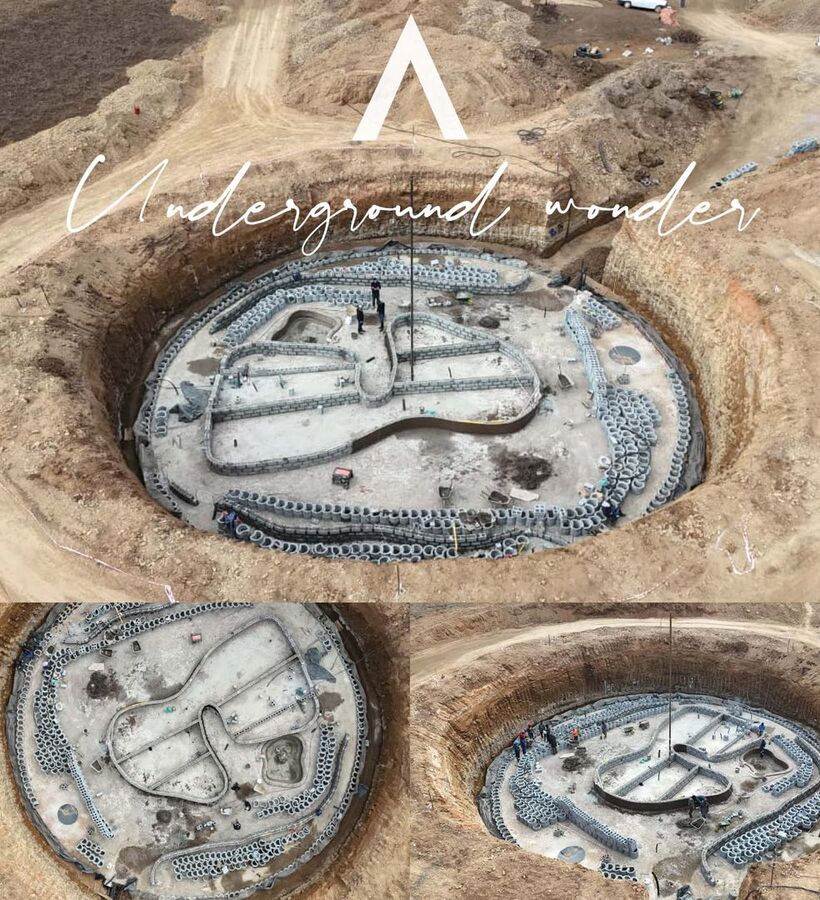 Circular excavated site for a future underground spa and pool with concrete shell, stacked block walls and workers on site surrounded by earthen berms