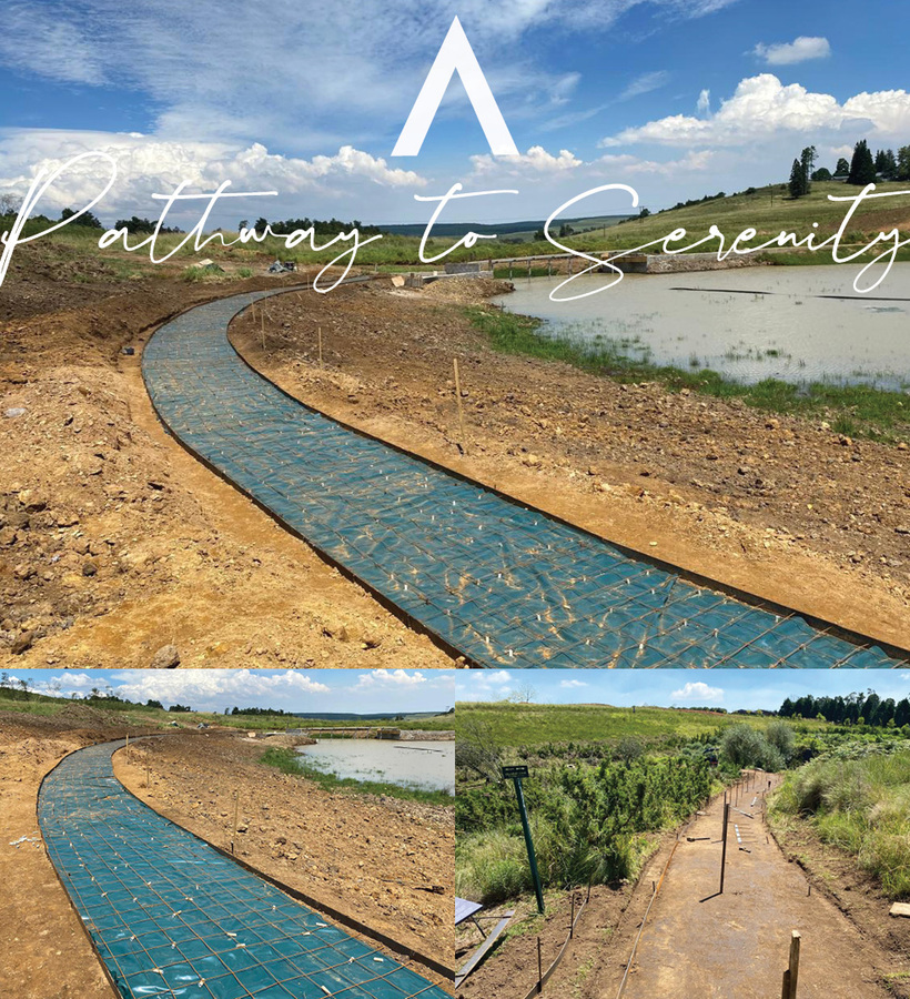 Curved lakeside walkway under construction beside a calm pond and rolling grassy hills, promising scenic, peaceful strolls.