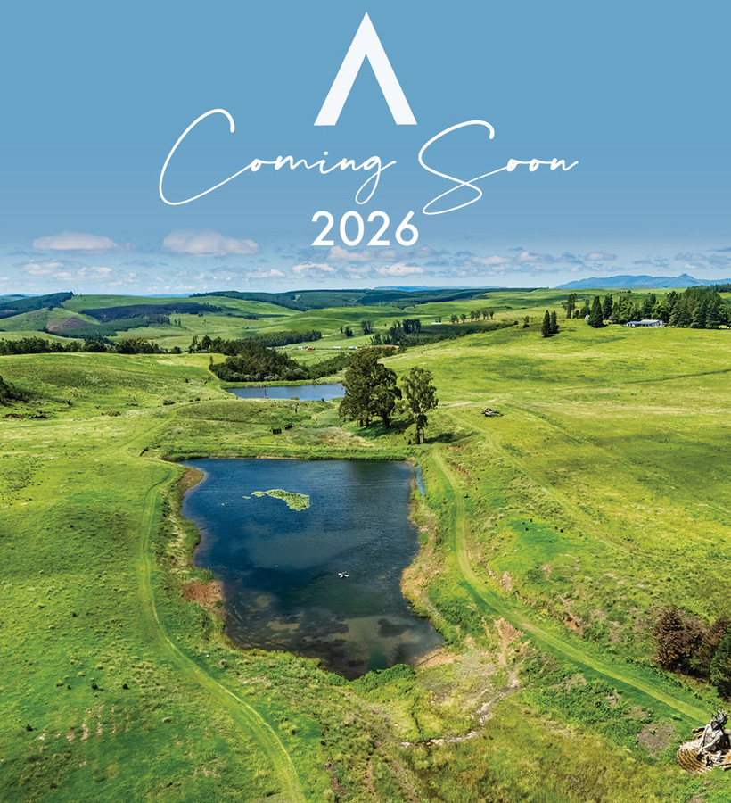 Aerial view of rolling green hills, ponds and scattered trees with a triangular logo and 'Coming Soon 2026' text overlay