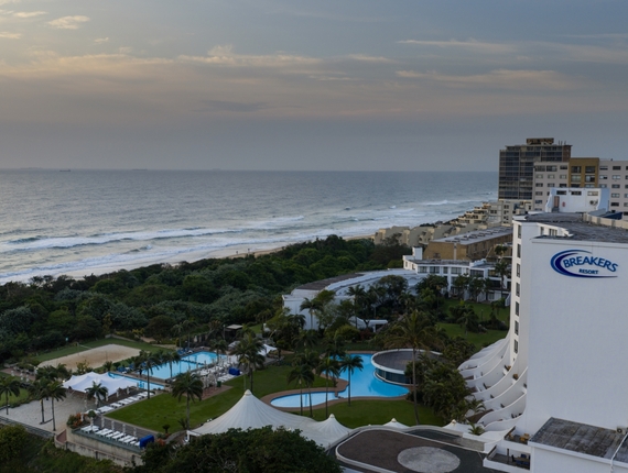 Oceanfront Breakers Resort with curved white facade, lagoon-style pools, palm gardens and direct beach access under a soft evening sky
