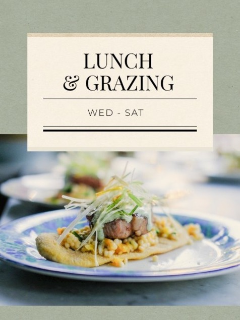 Gourmet lunch dish with fresh greens and grains on a decorative plate, promoting lunch and grazing Wed-Sat
