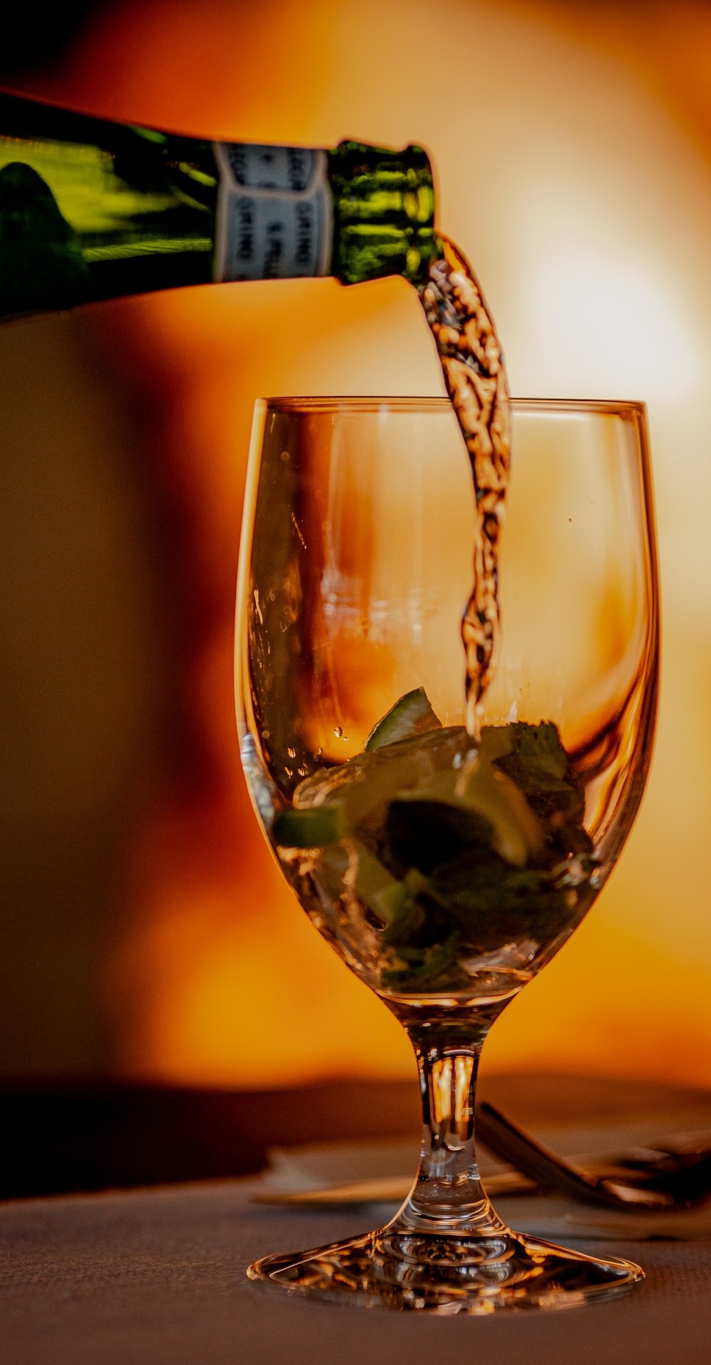 Napój nalewany do kieliszka z plasterkami cytryny i lodem w ciepłej, przytulnej atmosferze restauracji