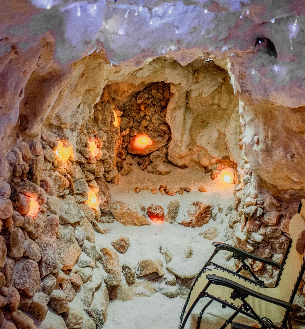 Unikalna solna grota do relaksu z kamiennymi ścianami i podświetlanymi solnymi kryształami oraz wygodnym leżakiem