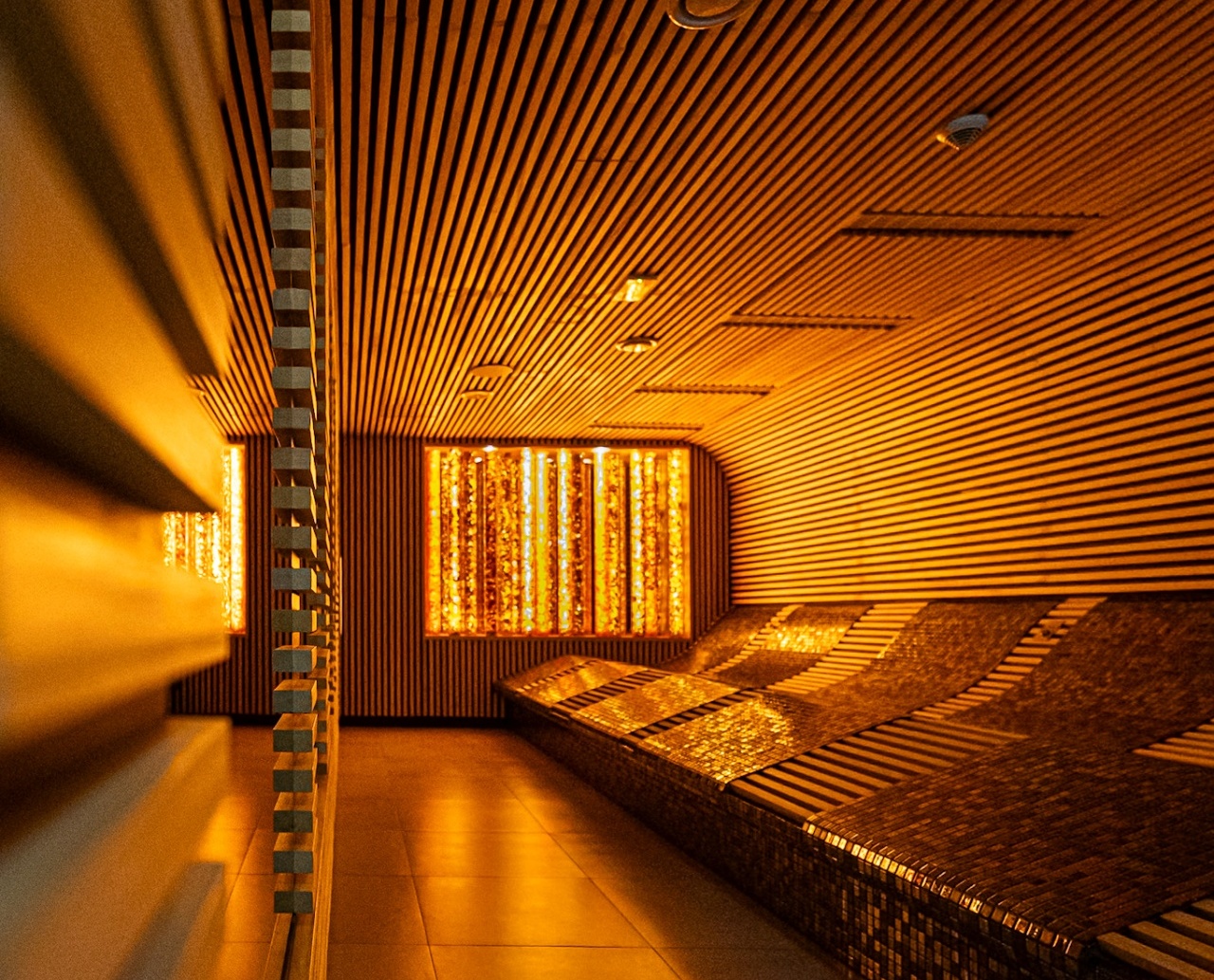 Elegancki pokój relaksacyjny spa z podświetlanymi ścianami i ergonomicznymi ławkami wyłożonymi mozaiką