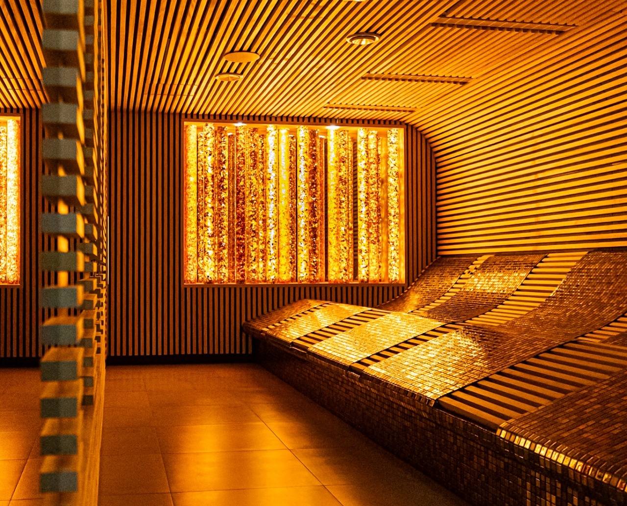Przytulne miejsce relaksu w spa z podświetlanymi, wyprofilowanymi leżankami i nowoczesnym drewnianym wykończeniem ścian i sufitu
