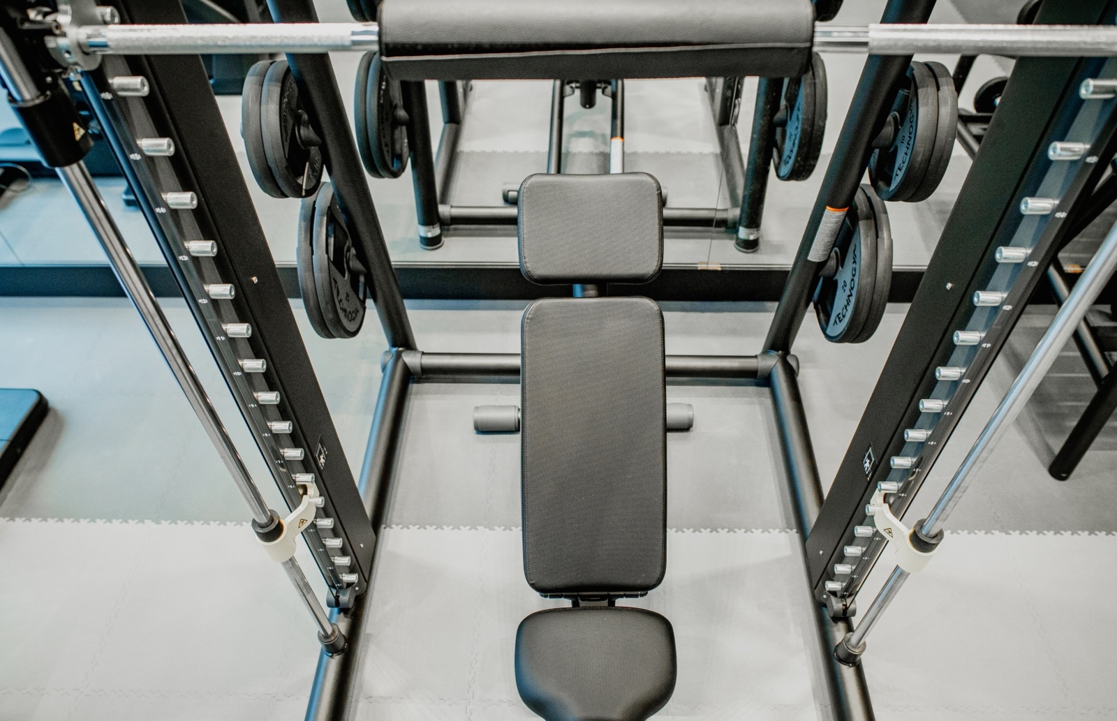 Nowoczesna siłownia hotelowa z wyposażeniem do ćwiczeń siłowych, ławką treningową i obciążeniami