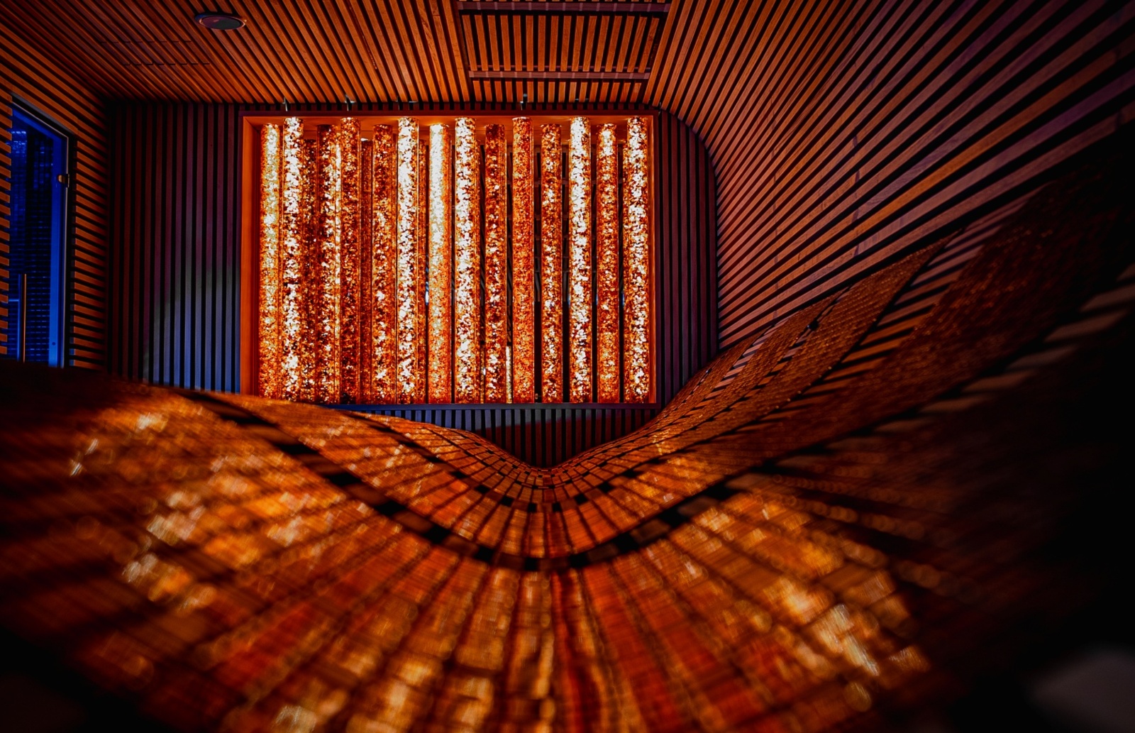 Relaksująca drewniana sauna z łagodnym oświetleniem i eleganckim panelem świetlnym na ścianie