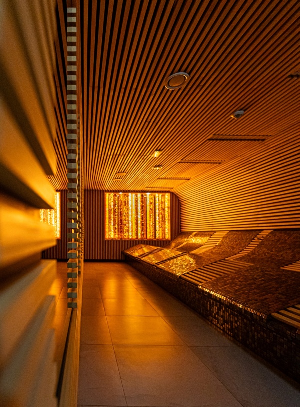 Elegancki pokój relaksacyjny spa z podświetlanymi ścianami i ergonomicznymi ławkami wyłożonymi mozaiką