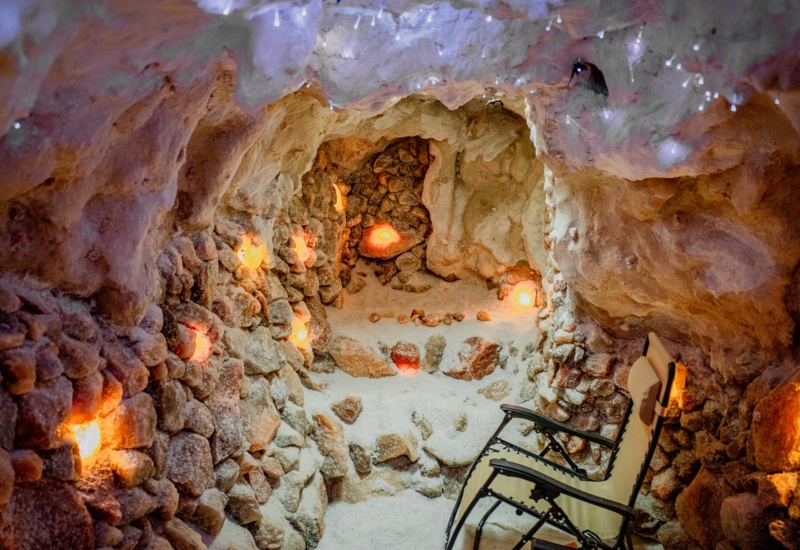 Unikalna solna grota do relaksu z kamiennymi ścianami i podświetlanymi solnymi kryształami oraz wygodnym leżakiem