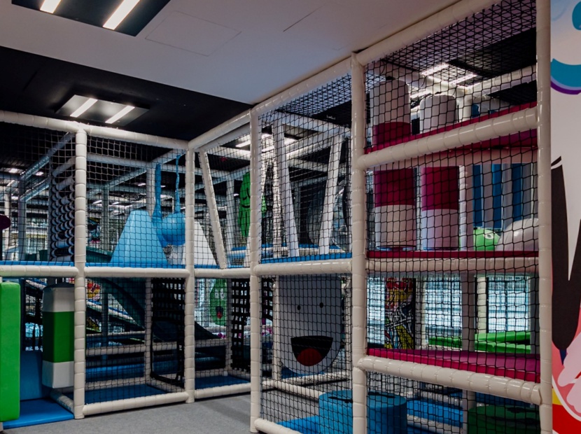 Kolorowy kryty plac zabaw dla dzieci z bezpiecznymi przeszkodami, zjeżdżalniami i miękkimi elementami do zabawy