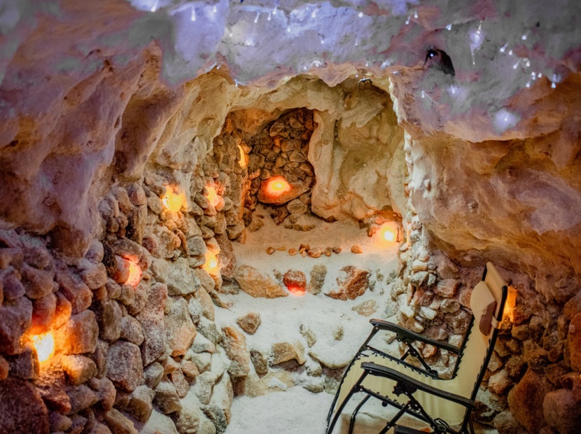 Kamienna grota solna z podświetlanymi kryształami soli, relaksujące miejsce z leżakiem do terapii solnej