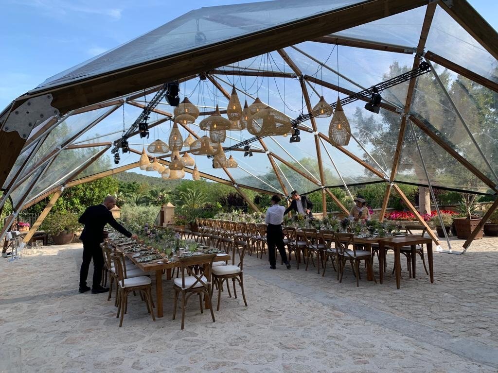 Menschen bereiten eine Hochzeitslocation auf Mallorca mit großen Tischen vor