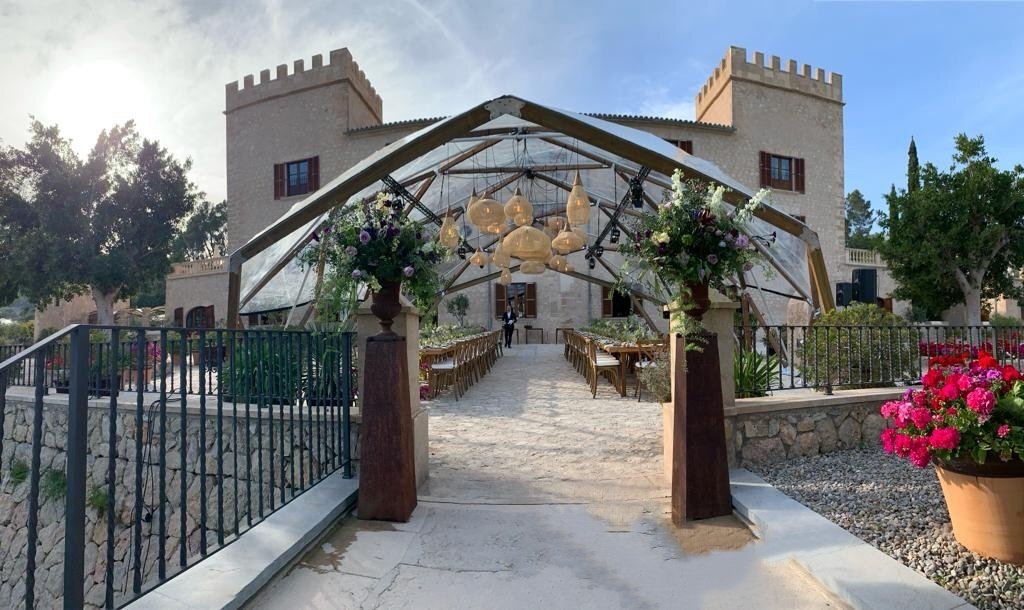 Schlossgebäude mit zusätzlichem Kunststoffdach und großen Tischen davor