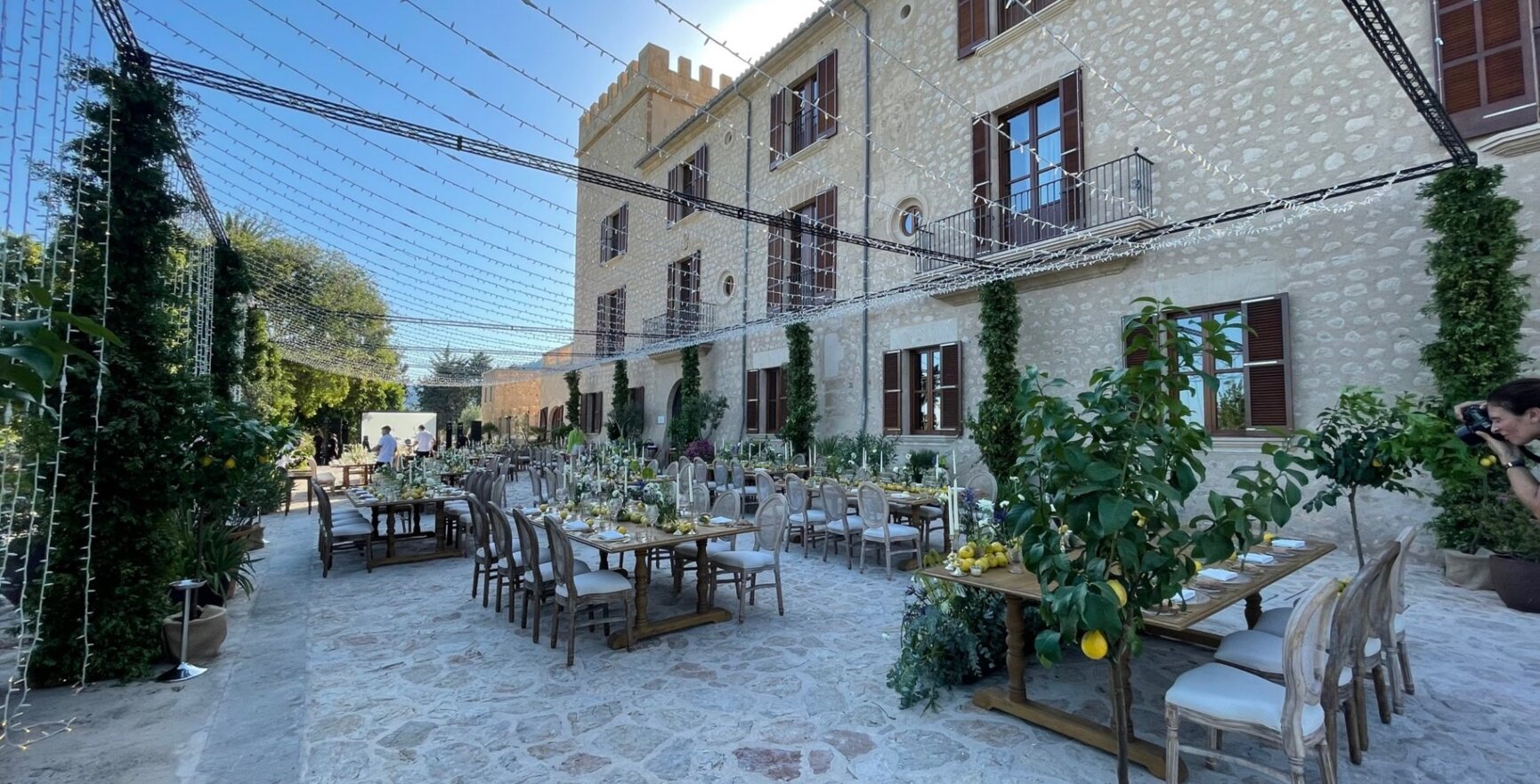 Gran local para bodas en Mallorca con muchas mesas decoradas con plantas verdes y limones