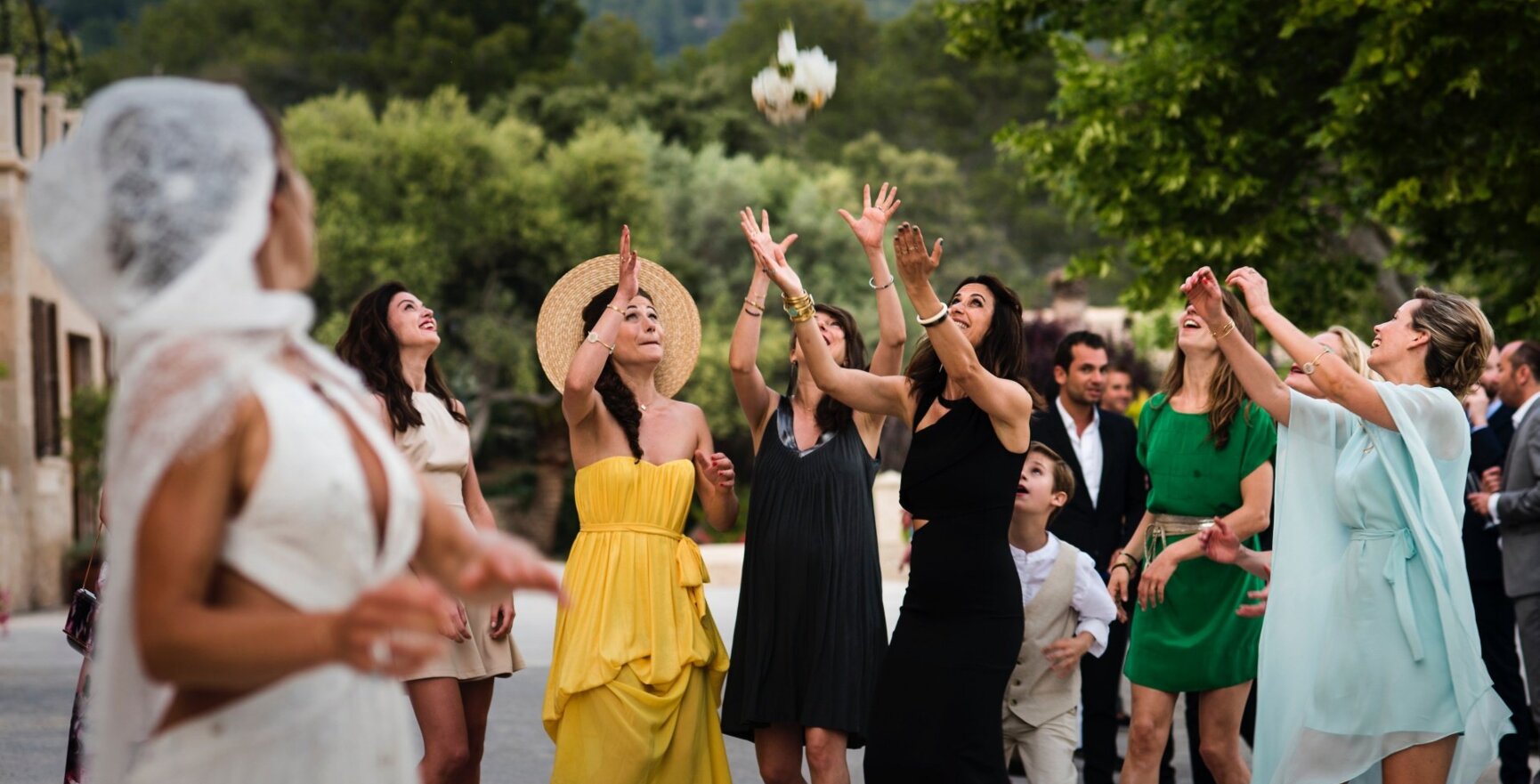 Invitadas de boda cogen el ramo de flores de la novia en una preciosa boda en Mallorca