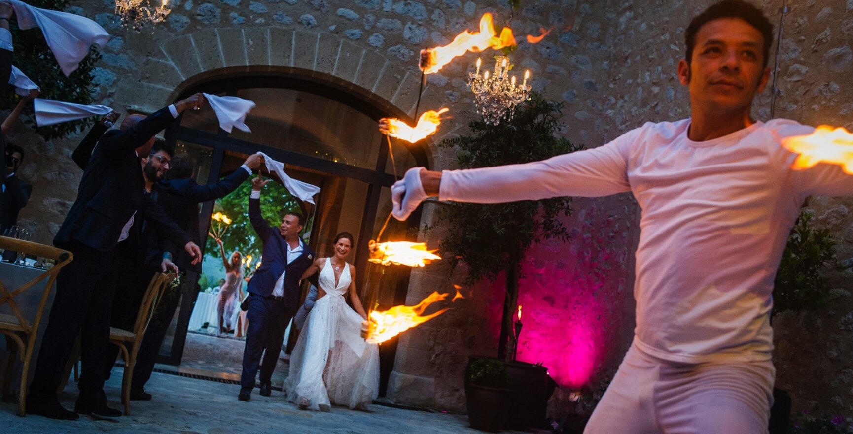 Una pareja de novios entra feliz a una boda en Mallorca con un espectáculo de fuego