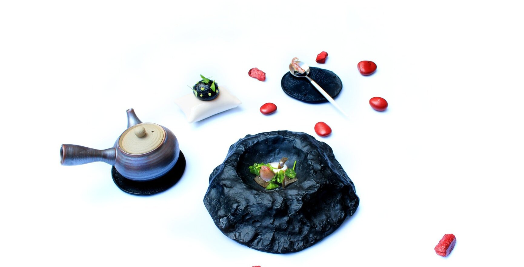 Elegantes modernes japanisches Teeset mit einzigartigem schwarzem Steingeschirr und kunstvoll garniertem Vorspeisenteller auf weißem Hintergrund