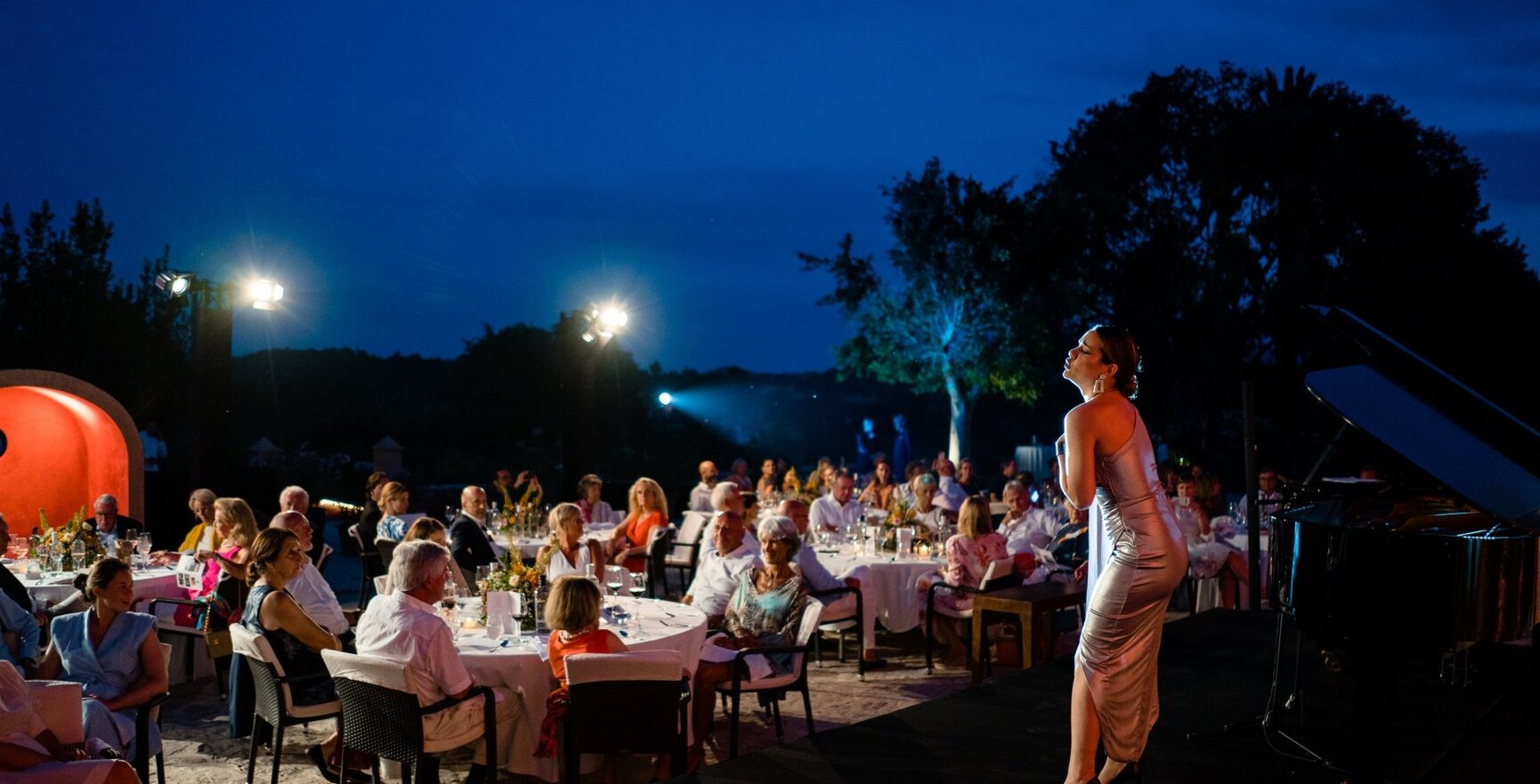 Eine Sängerin steht auf der Bühne und tritt auf, während die Hotelgäste zu Abend essen