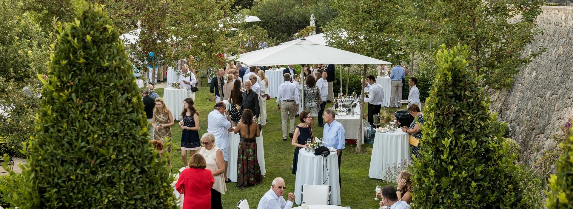 Eine Hochzeitsfeier im Garten des Luxushotels auf Mallorca mit vielen Tischen