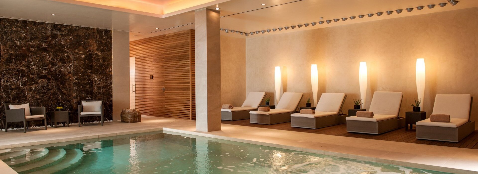 A cozy spa area at the luxury hotel in mallorca with an indoor pool and day beds