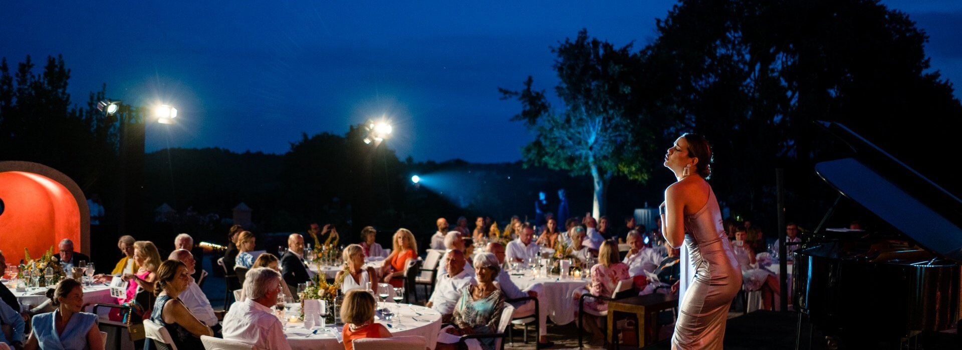 Eine Sängerin steht auf der Bühne und tritt auf, während die Hotelgäste zu Abend essen