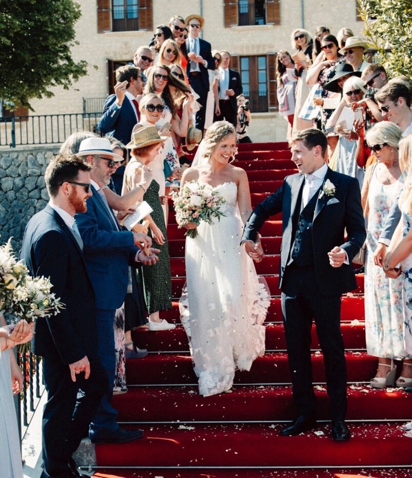 Ein Brautpaar geht glücklich die Treppe eines Hochzeitshotels auf Mallorca hinunter