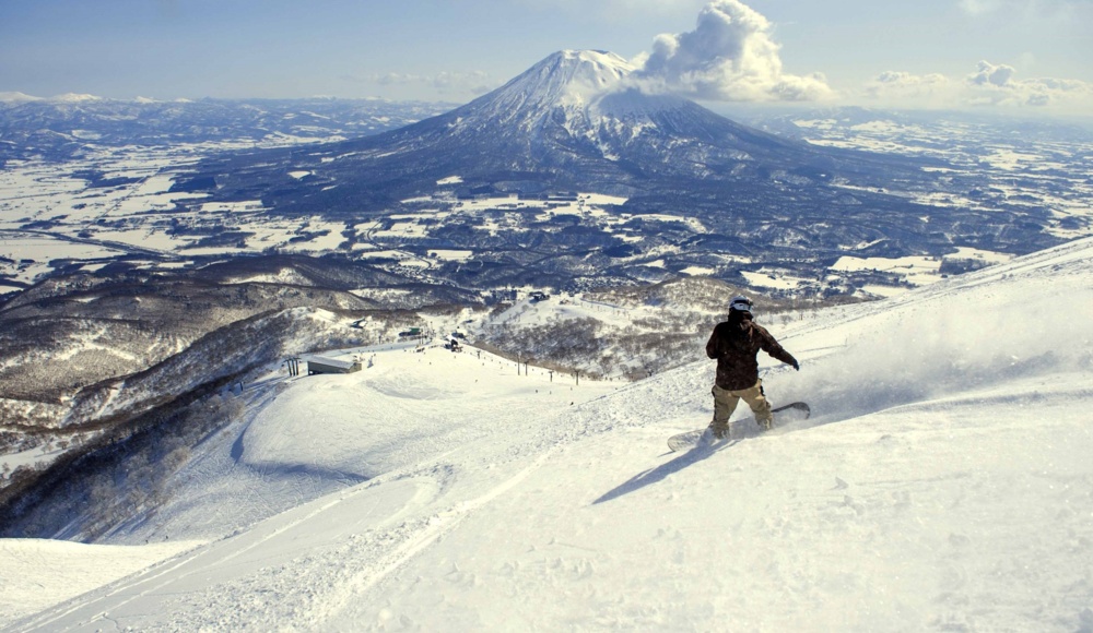 A snowboarder gracefully descends a snowy slope, showcasing skill and excitement