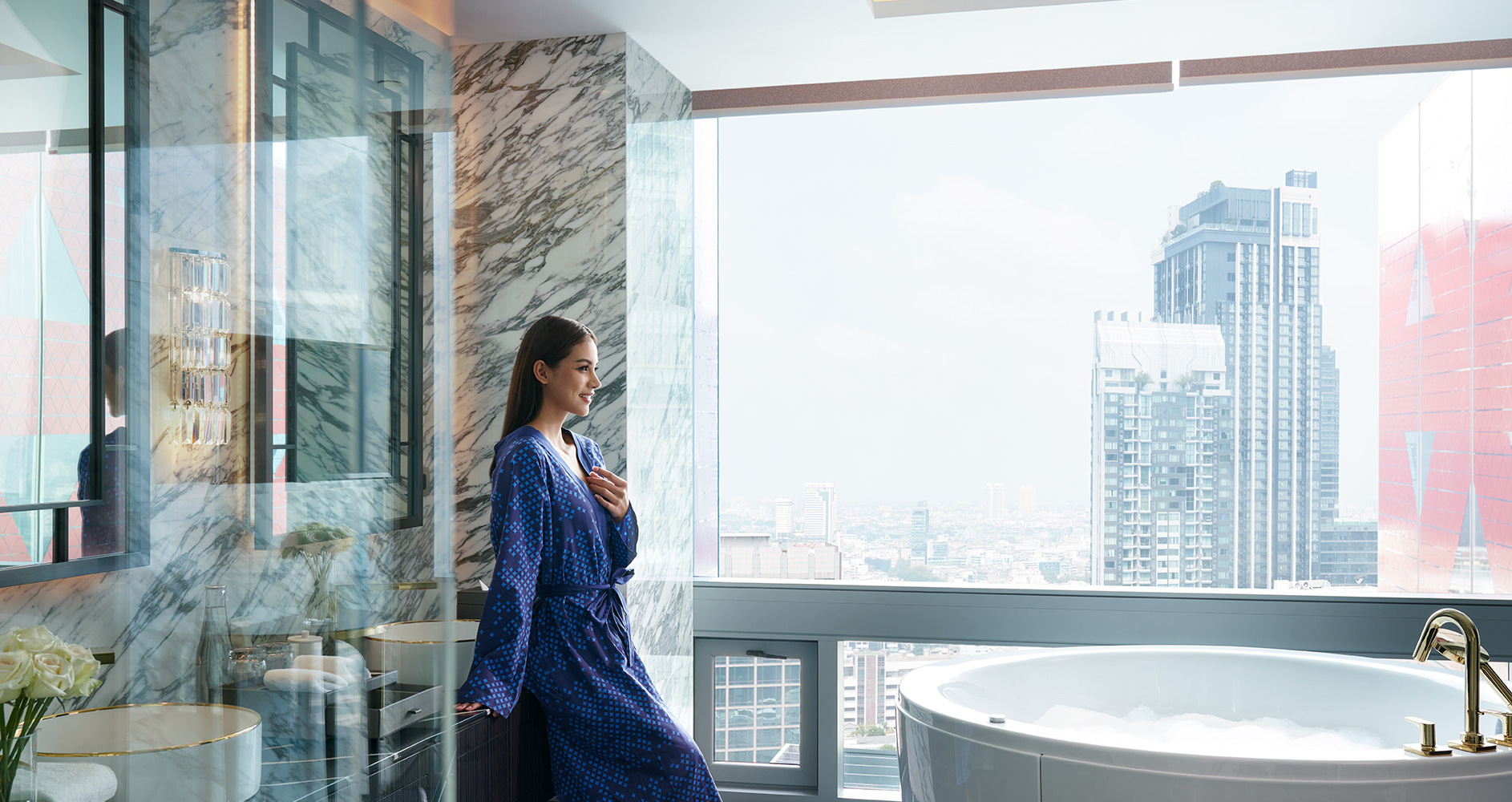 A woman in a bathrobe stands gracefully in front of a bathtub, exuding a sense of relaxation.