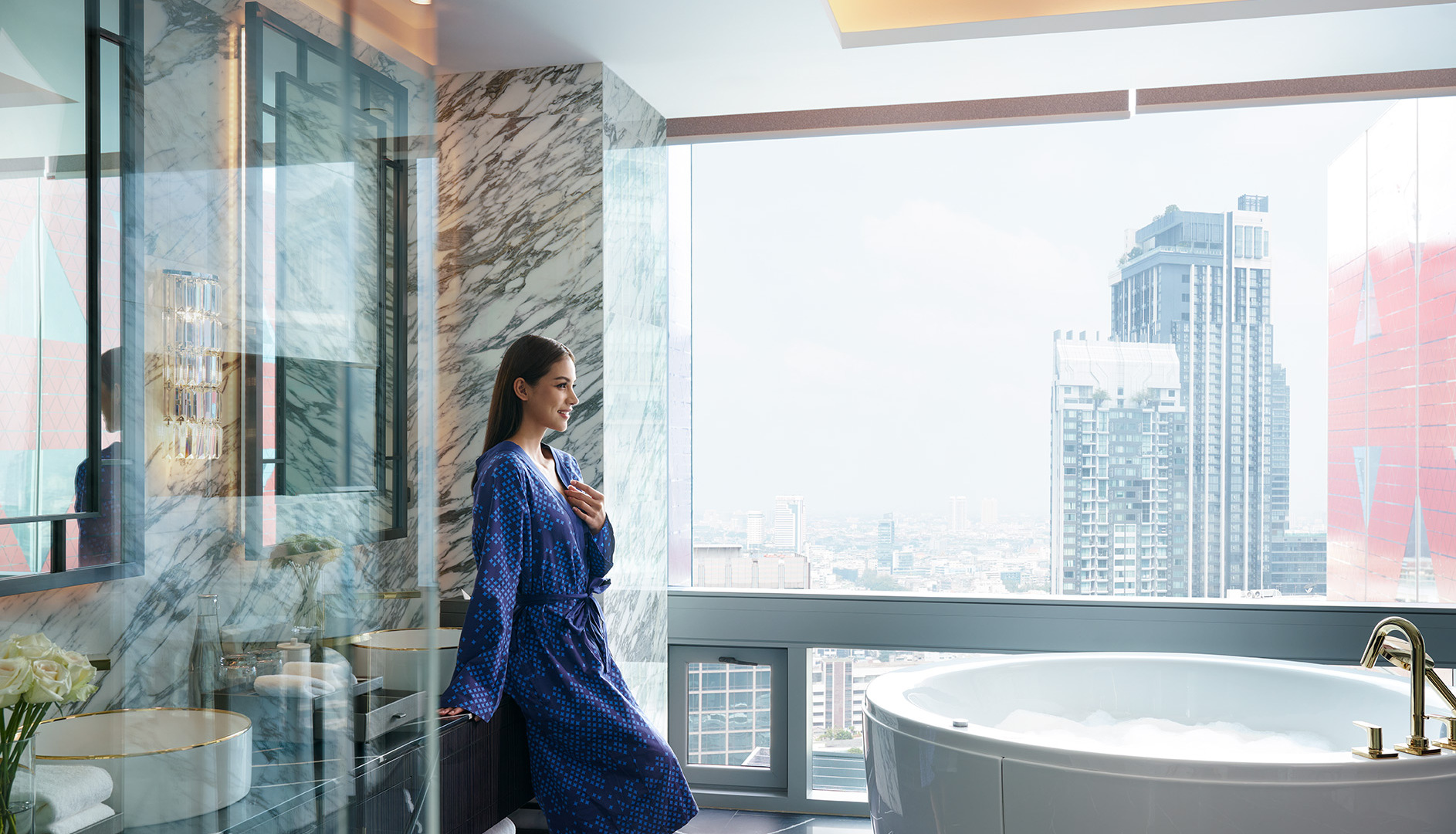 A woman in a bathrobe stands gracefully in front of a bathtub, exuding a sense of relaxation.