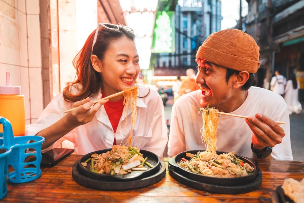 A couple enjoying their food at a Chaorenkrung road restaurant