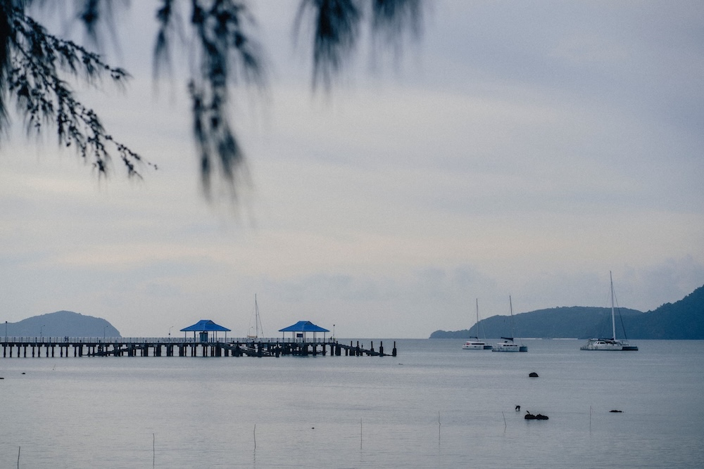 Coastal pier and sailing boats highlighting relaxing activities in Phuket