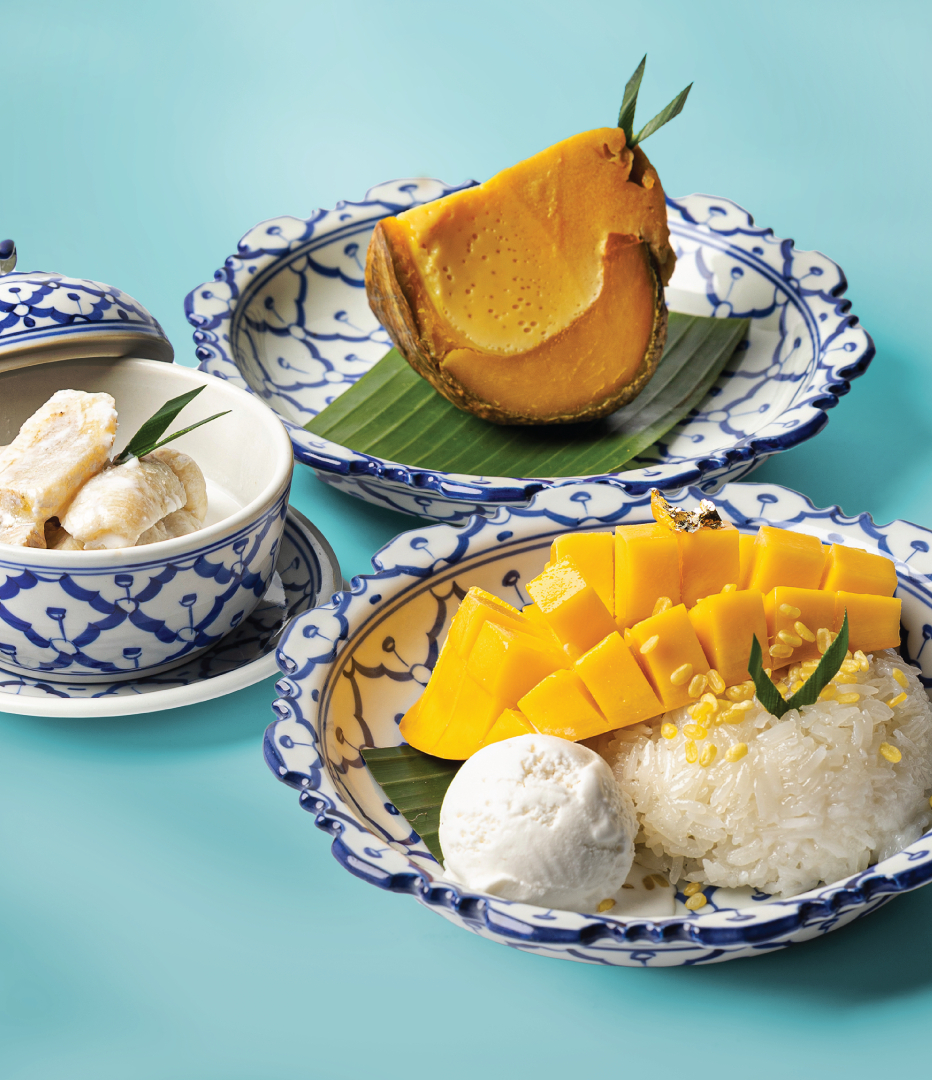 Mango sticky rice with coconut ice cream, pumpkin custard and banana served in blue Thai patterned ceramic bowls