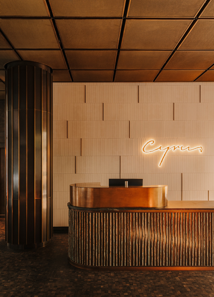 Recepcja hotelu w centrum Wrocławia The Cyrus z logo obiektu i hotelowym stolikiem