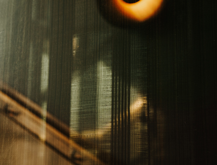 Rozmazowany i lekko tajemniczy widok przez matową szklaną przegrodę z ciepłym, okrągłym światłem w tle.