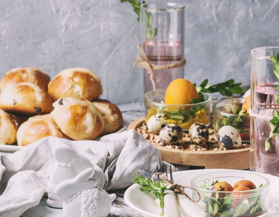 Stół z pieczonymi bułeczkami, quail eggs dekorowane zielenią i szklanki z różowym napojem w rustykalnym stylu