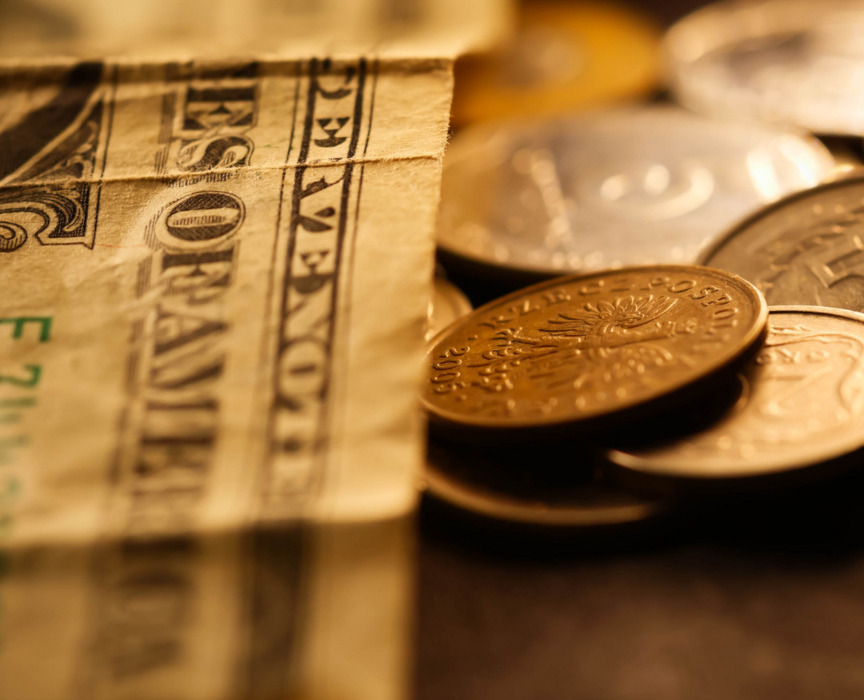 Zbliżenie na różne monety i banknoty, symbolizujące płatności i budżet podróży.