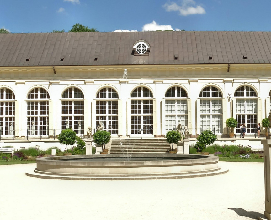 Elegancki budynek hotelu z dużymi oknami i fontanną na dziedzińcu, w słoneczny dzień z niebieskim niebem