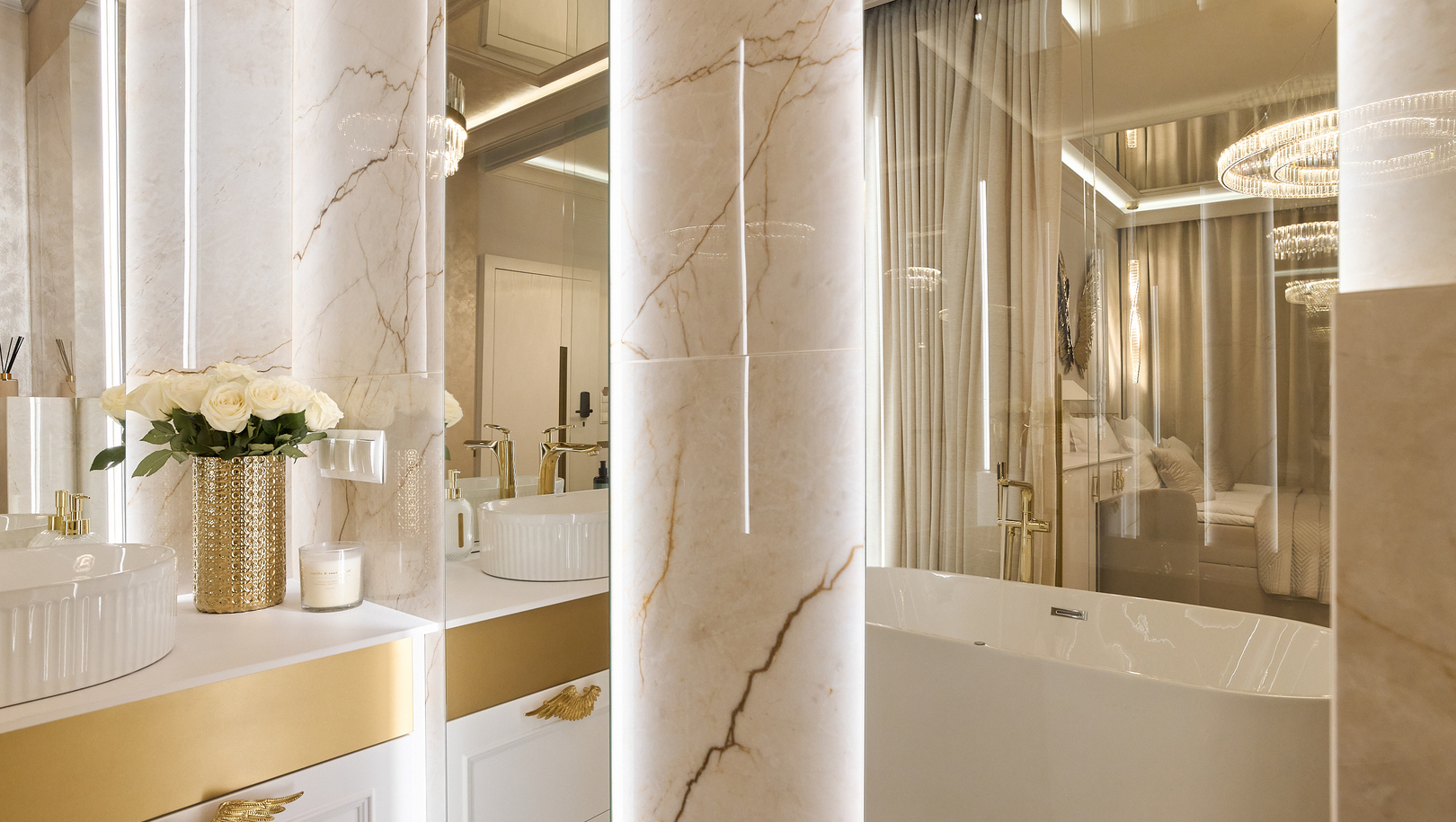 Luksusowa marmurowa łazienka z wolnostojącą wanną, złotymi bateriami, toaletką z białymi różami w złotym wazonie i ciepłym oświetleniem