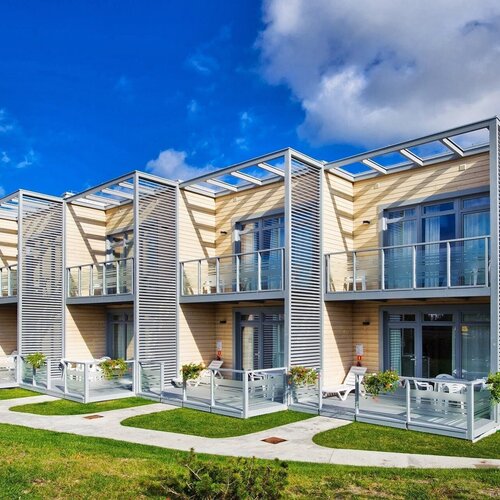 Modern rooms with private terraces and balconies, glass balustrades, pergolas, sunbeds and flower pots.